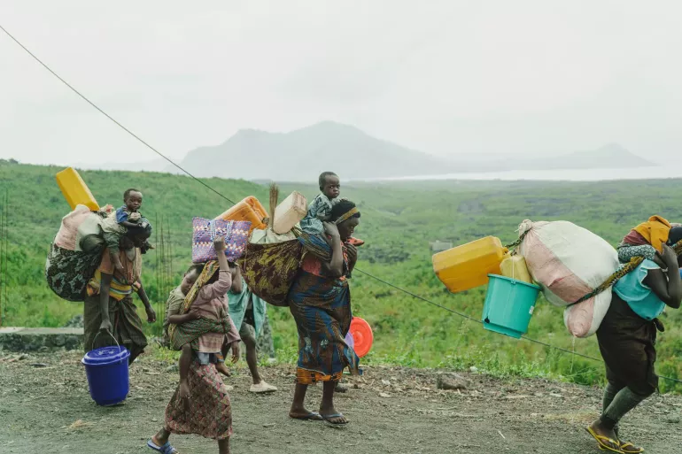 Displaced families carry their belongings and children and walk the roads.