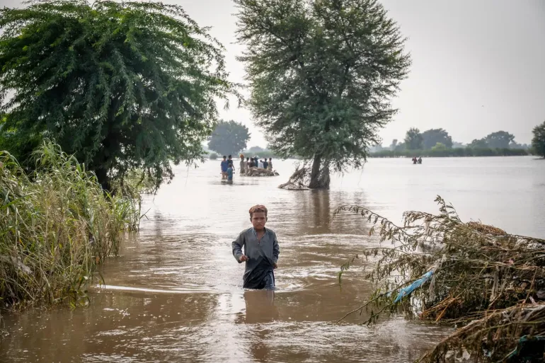 Boy walks in the middle of a flood