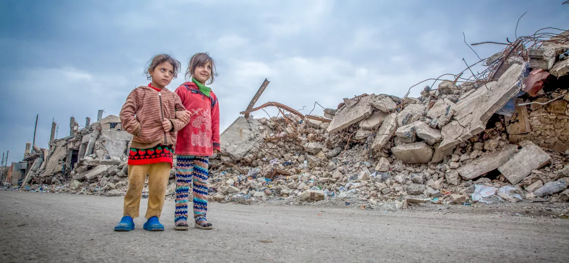 Dos ni&ntilde;os caminan donde muchos edificios han sido totalmente destruidos: Mosul, Iraq.