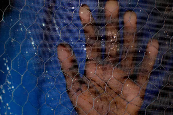 Nigeria. A girl pushes her hand against a screen.