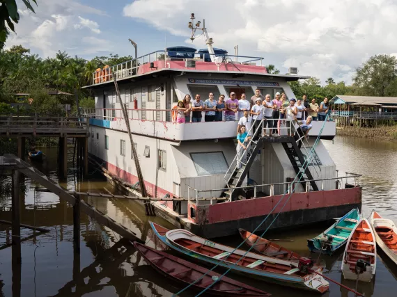 A ferry boat full of passengers on the river.