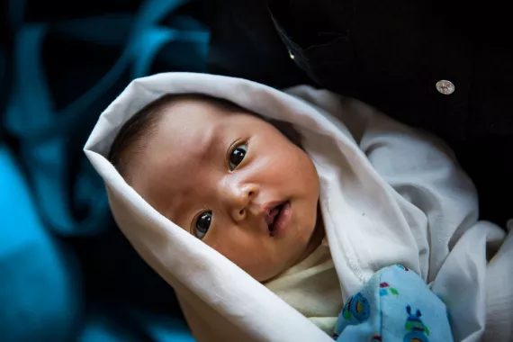 A new-born baby swaddled in blankets