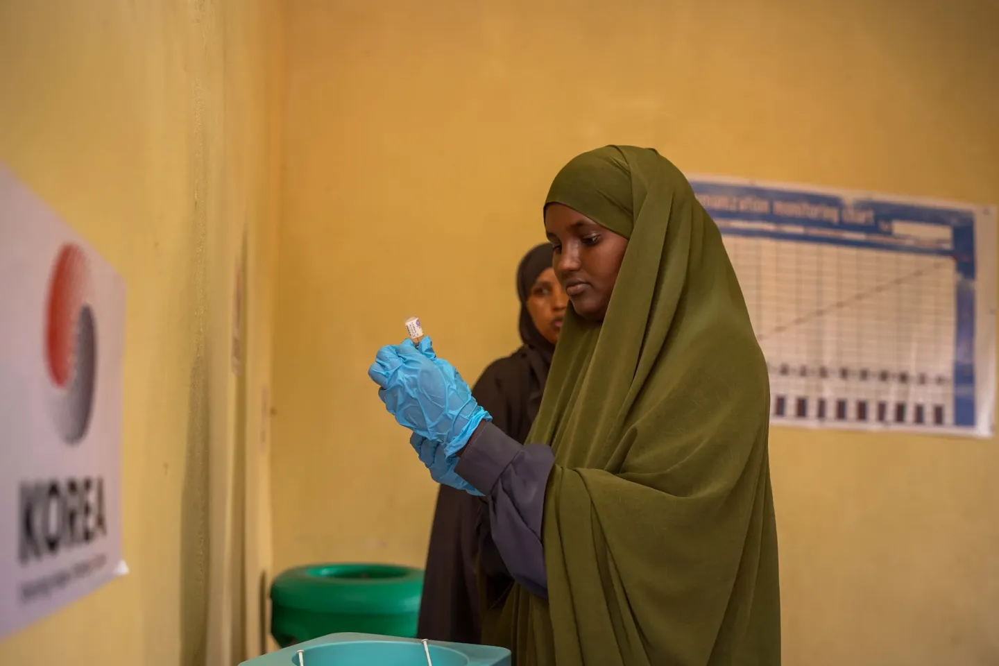 Amina prepares to vaccinate a child at Xalanley Health Centre, where she supports families to access essential immunization services.