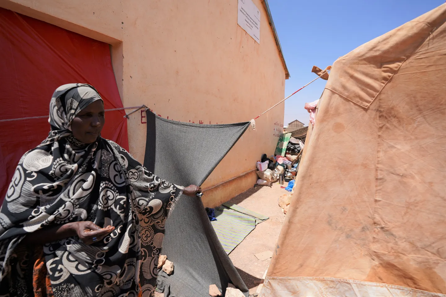 Zainab pointing to her shelter