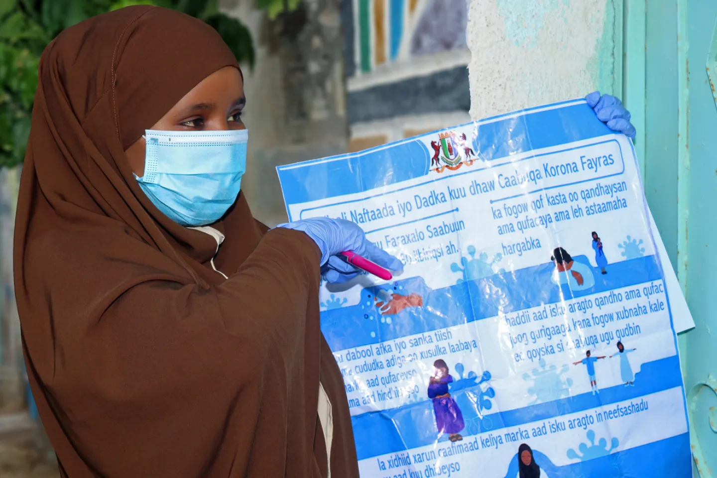community-social-mobilizer-holding-covid-19-awareness-poster