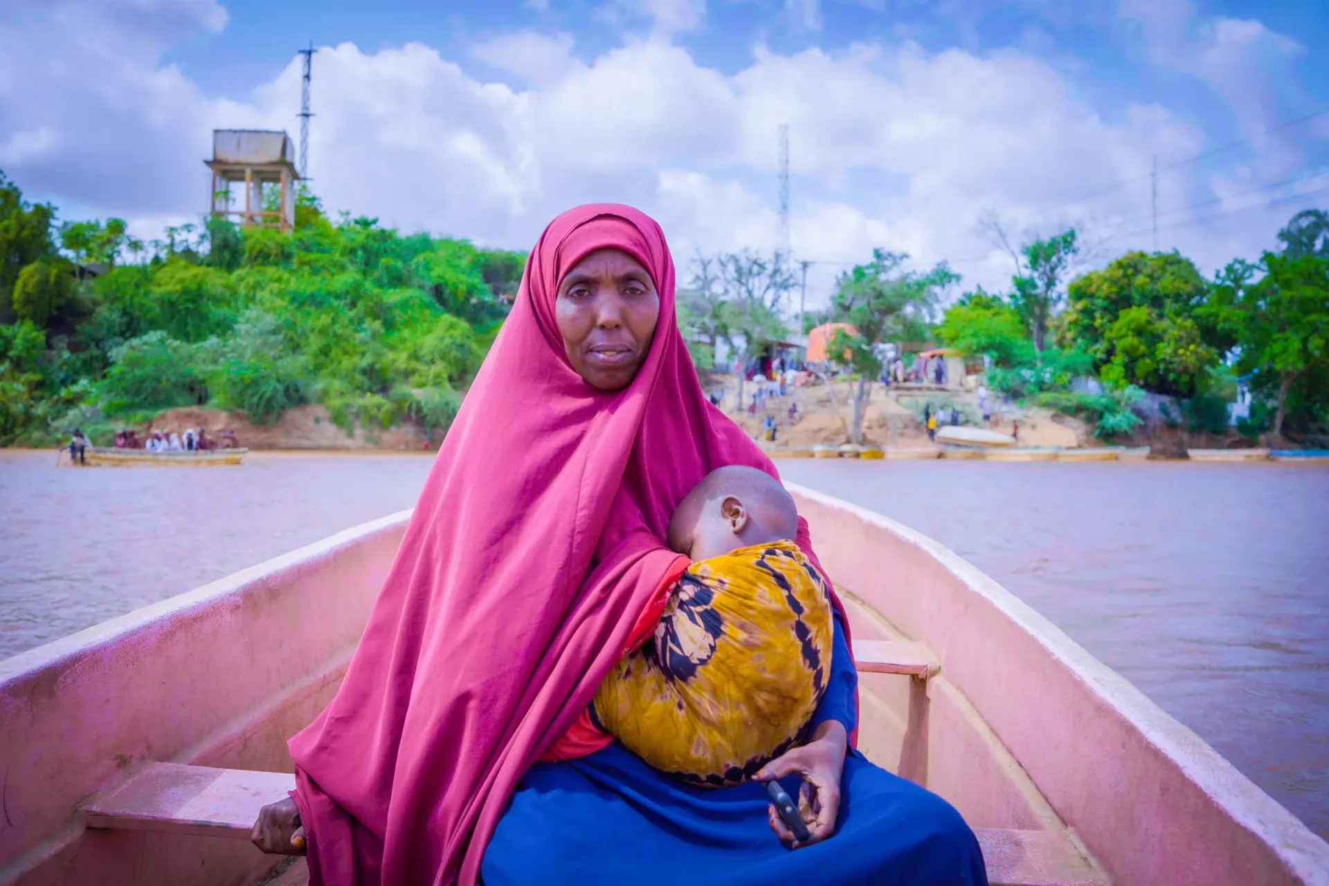 Asho Abdullahi travels by boat with her youngest child to a health centre in Bardhere.