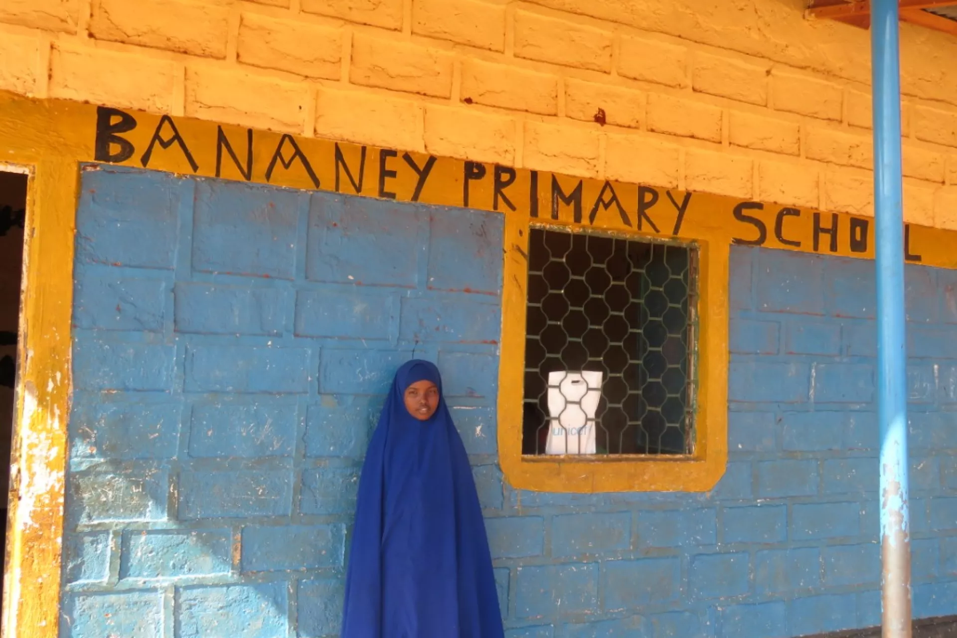 Kowsar standing outside her classroom 