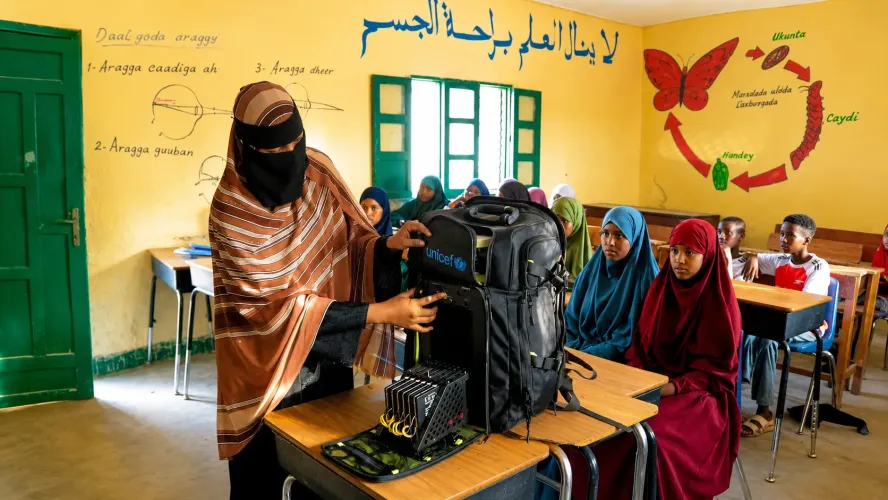 Khadan sets up the solar-powered Tespack in her classroom in Geedbalaadh village, Gabiley District, while her Accelerated Basic Education (ABE) learners watch with interest.
