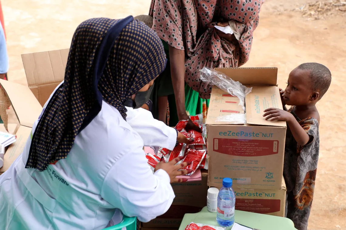 Nurse Burhano gives RUTF to mothers with children in the OTP.