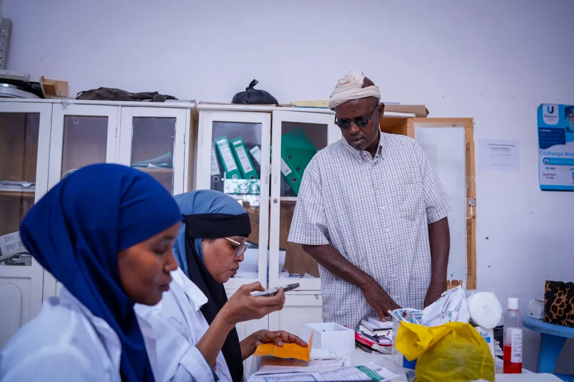 Mohamed consults with health workers on his child&rsquo;s health after bringing the child for care, receiving guidance on treatment and follow-up.