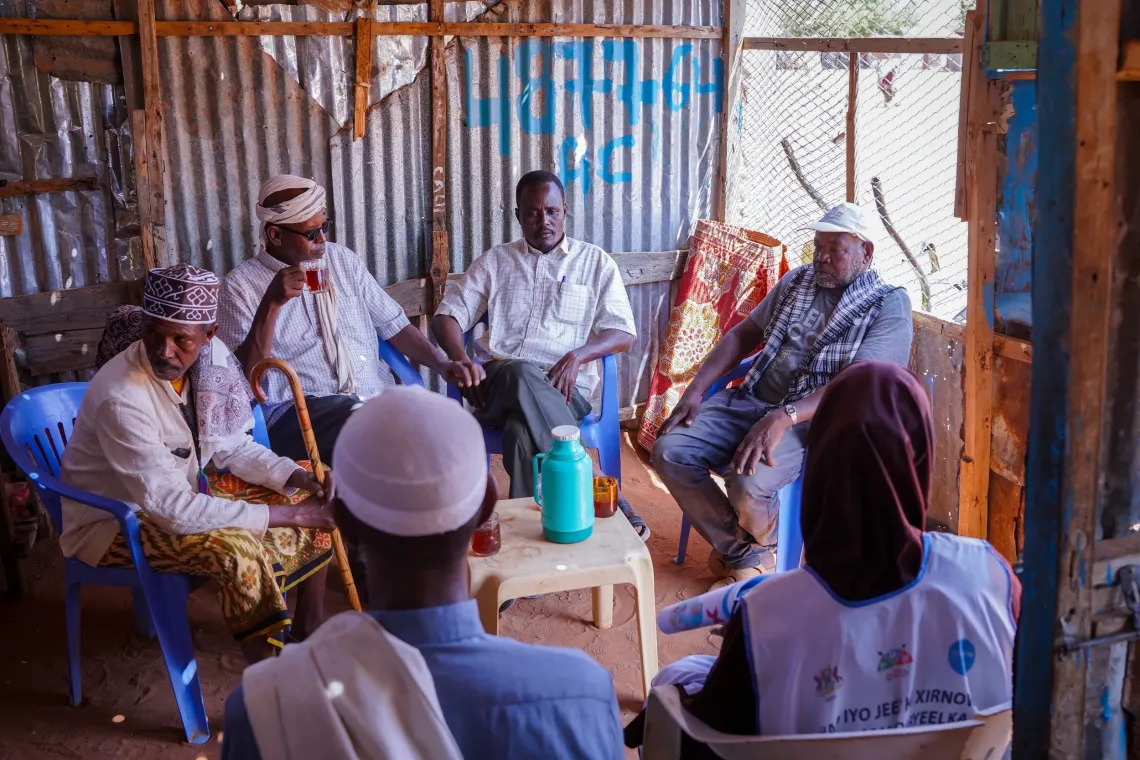 Mohamed sits in a tea shop with other fathers, sharing his experience as a father champion and encouraging men to take an active role in their families&rsquo; health and wellbeing.