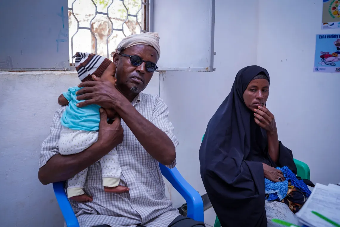 At the health centre, Mohamed and his wife bring their child for a routine health check, ensuring continued care and wellbeing.