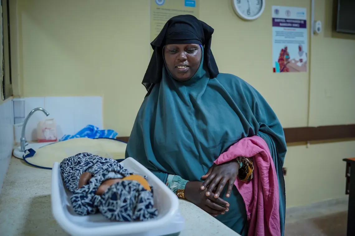 Falastiin Abdullahi looks on as her newborn baby is weighed during a follow-up visit at the Kangaroo Mother Care unit at Banadir Hospital.