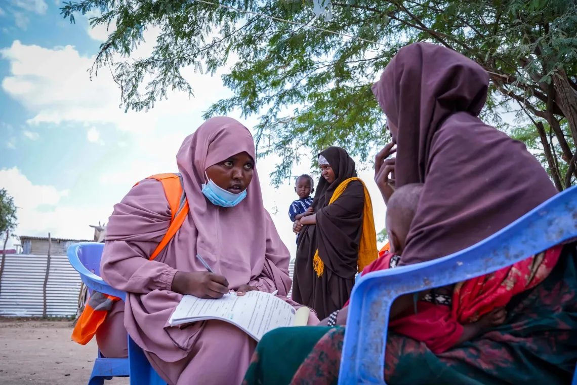 Social mobiliser Leylo Hassan speaks with a caregiver in Bardhere's displacement camps, providing information on the importance of vaccination and helping families access lifesaving immunization services.
