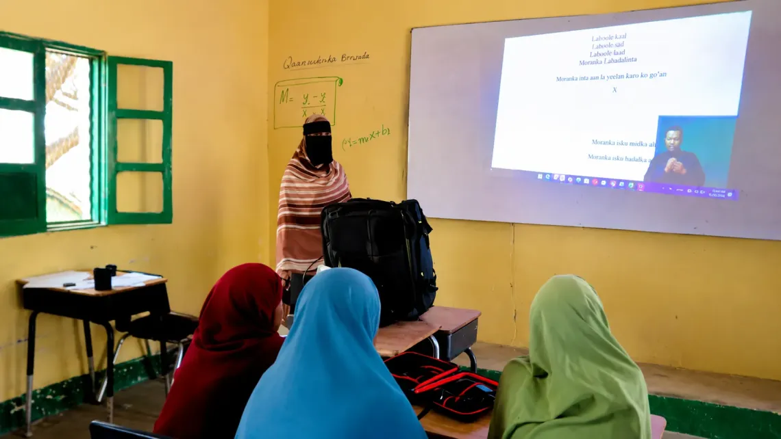 Using the Tespack as a projector, Khadan's ABE learners follow a lesson displayed on the classroom wall in Geedbalaadh village, Gabiley District.