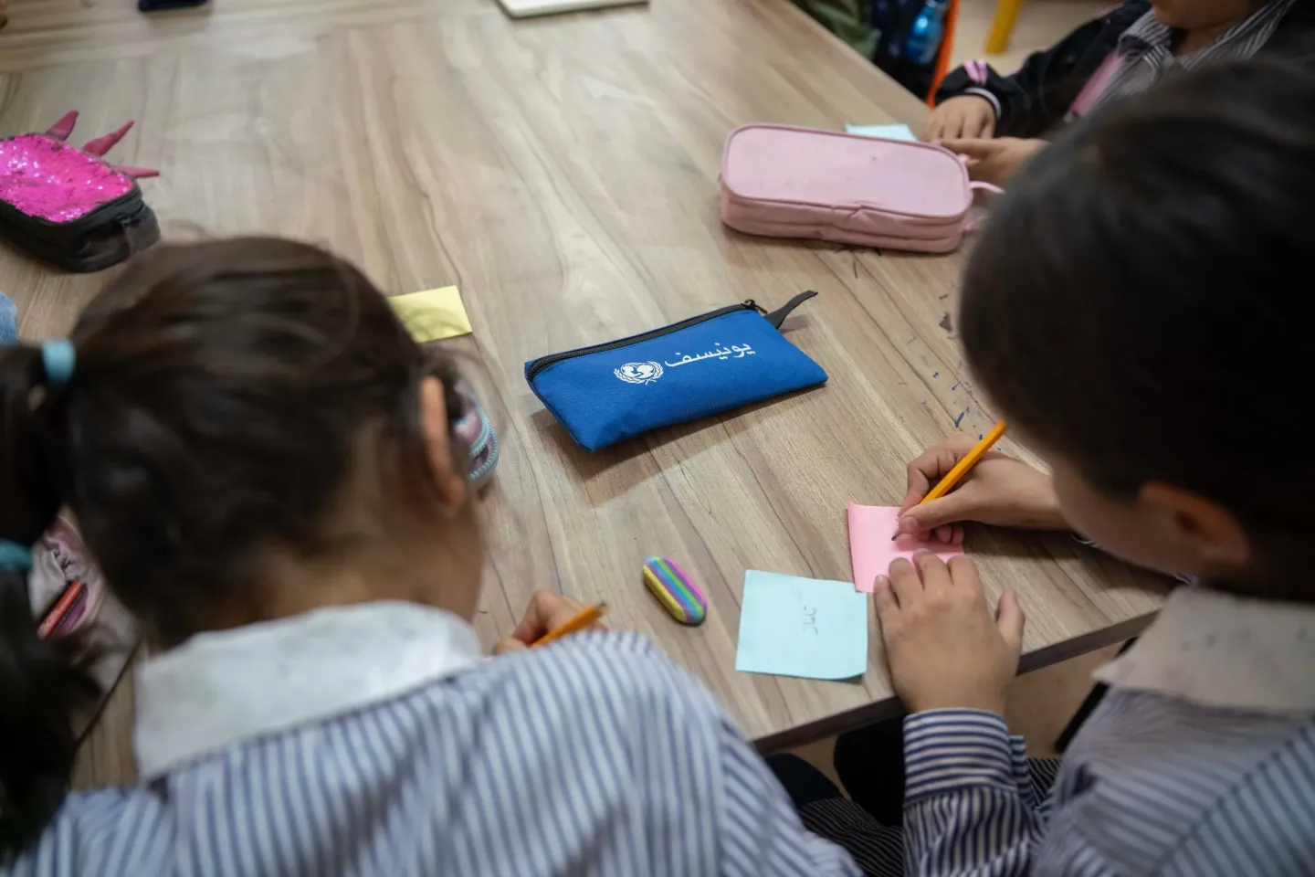 Palestinian girls writing at a UNICEF-supported psychosocial and educational support programme. 