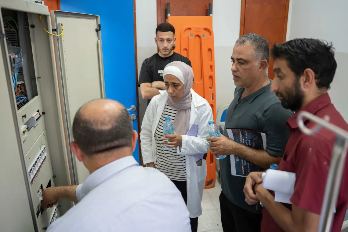 Engineer Abdullah Odeh shows staff at the Anabta primary care center how to operate the solar panel&rsquo;s electrical interface. 