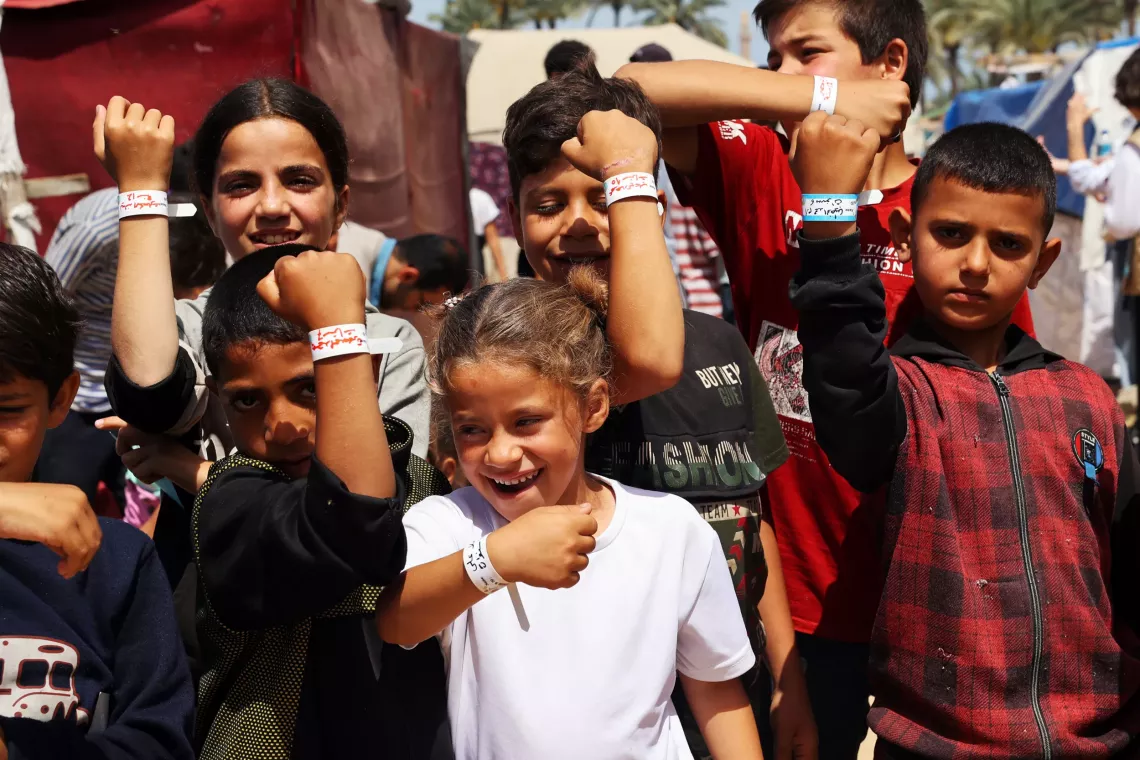 Children in Rafah, southern Gaza Strip, show off their identity bracelets, a means of reuniting them with their families in case of threat or hurried displacement.