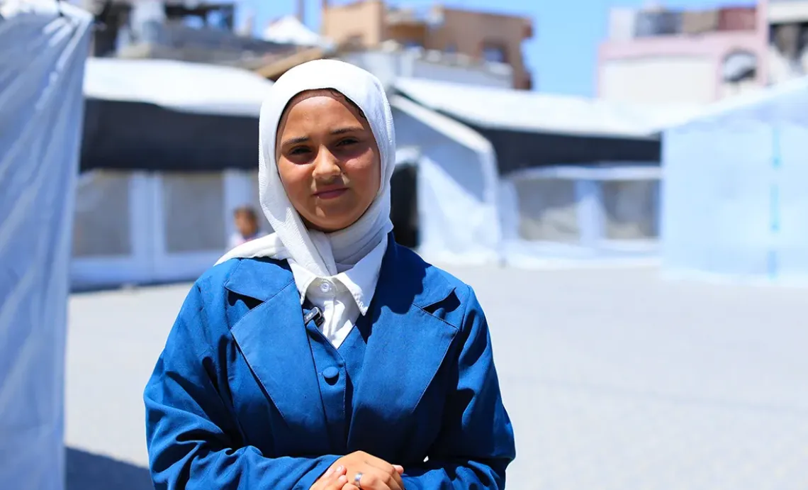 Hadeel in front of tents
