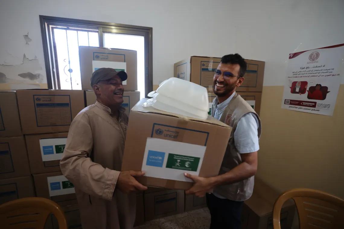 An older man collects a hygiene kit distributed by UNICEF and partners that includes critical hygiene items for washing up, collecting clean water, and so on.