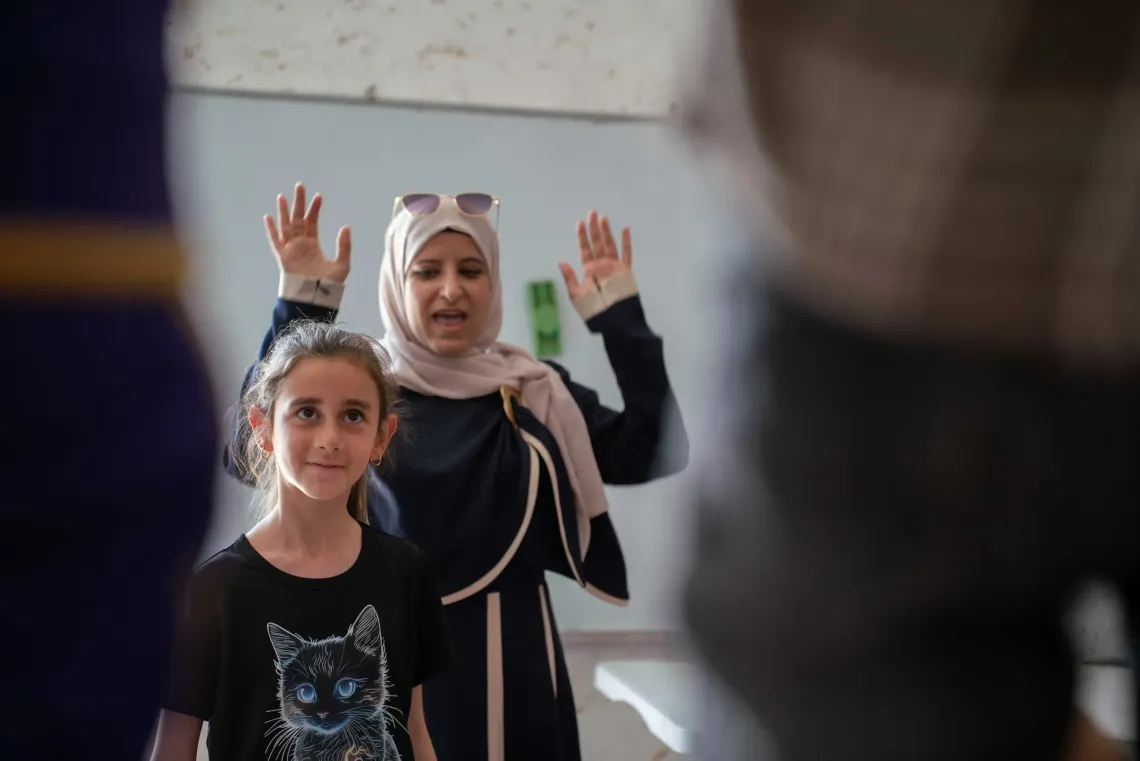 Lina, 9, participates in an exercise that helps children let off steam alleviate psychological distres at a UNICEF-supported program in her village of Qaryut.