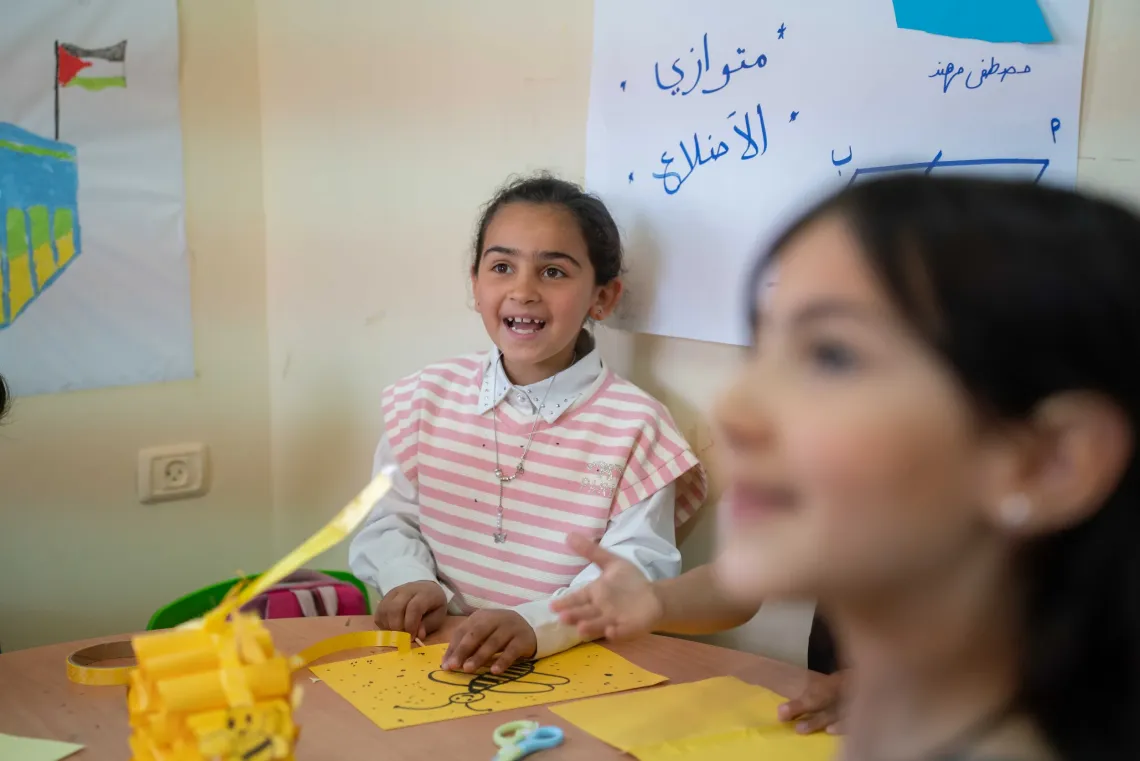 Malak, 8, laughs with her friends at the supportive program in her village.