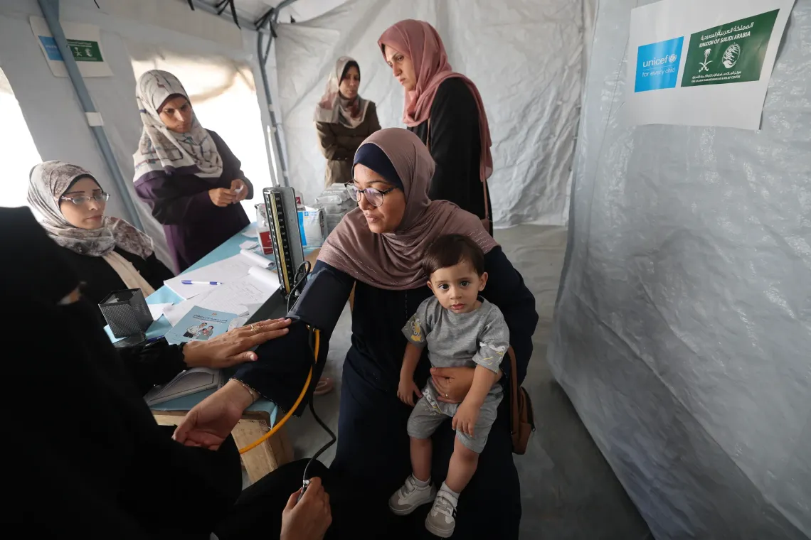 Palestinian mother, Rina, has her own blood pressure tested while visiting the clinic for her son, Yusuf&rsquo;s vaccinations. Yusuf was previously diagnosed with malnutrition but improved with supplementation and monitoring.