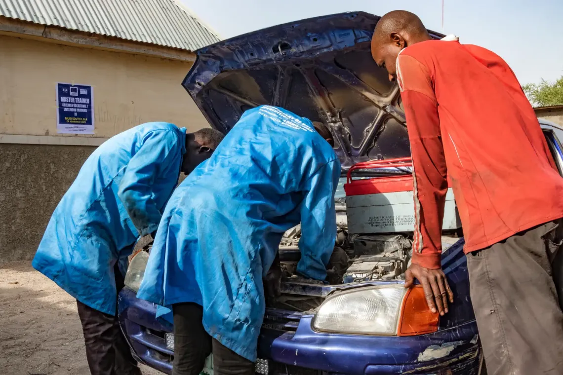 Nigeria. Two young people formerly associated with an armed group learn about automobile mechanics.