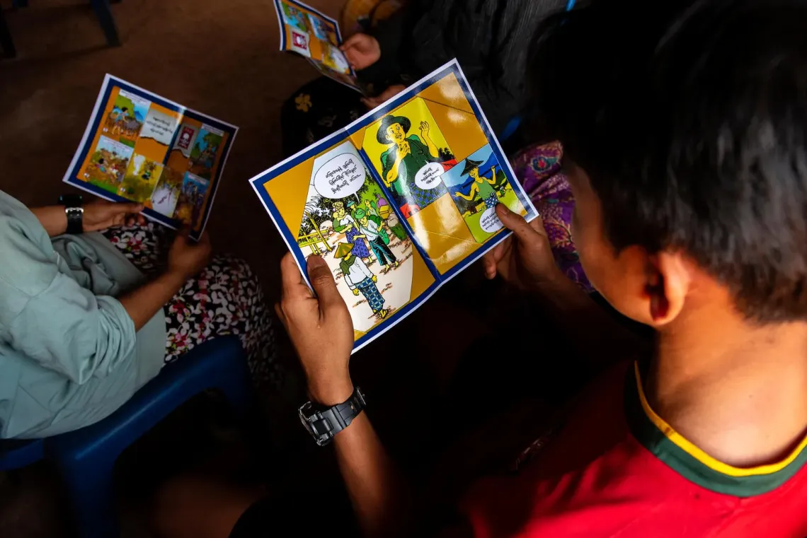 Myanmar. A child reads a mine risk education brochure during a UNICEF-led awareness session at a temporary learning centre in Shan State, Myanmar.