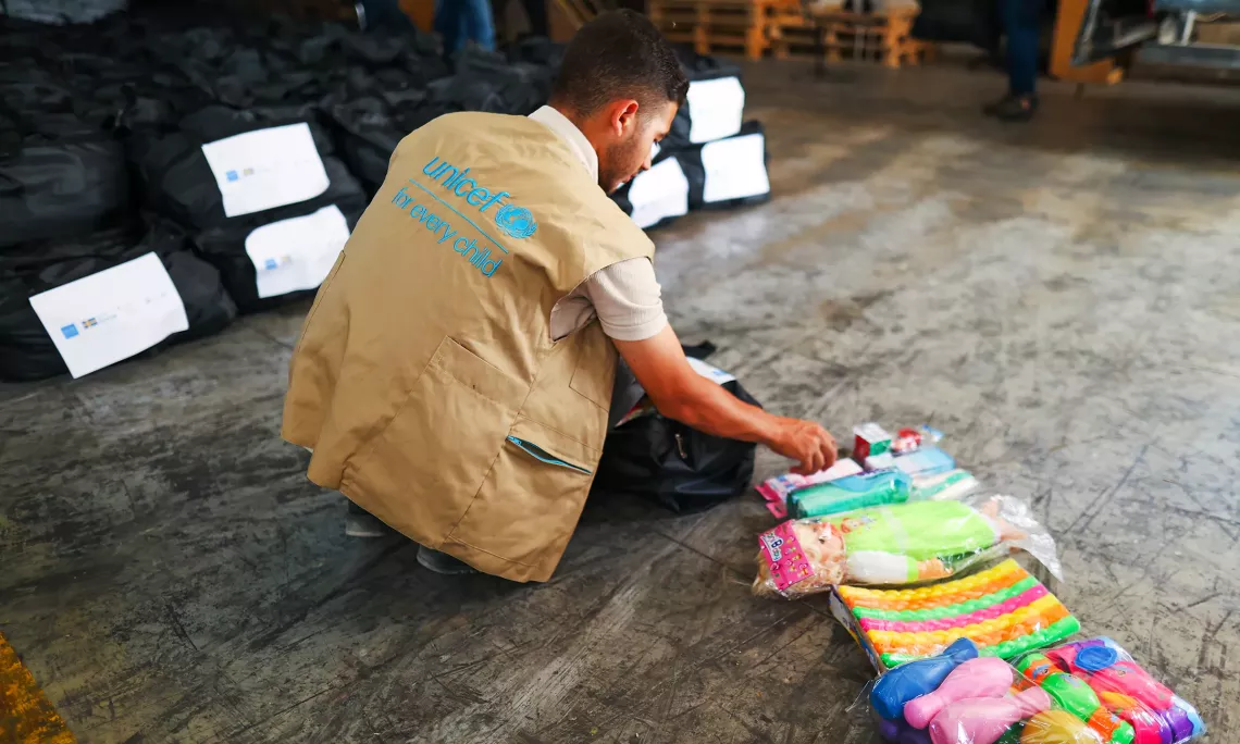 A UNICEF staff member sorts one of the 3,000 duffel bags filled with toys and art supplies for distribution to the northern Gaza Strip.