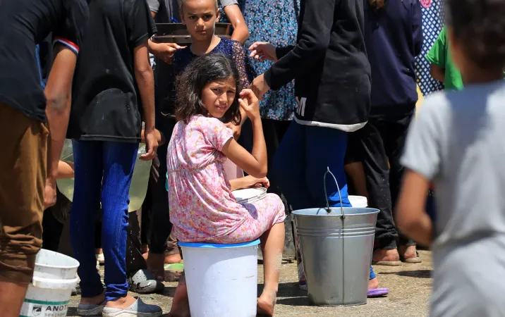 Children and their families fetching water from a UNICEF-supported water tank in Deir al-Balah, in the Gaza Strip. UNICEF water tanks distribute drinking water to thousands of residents thanks to the support of the government of Sweden and Australia.