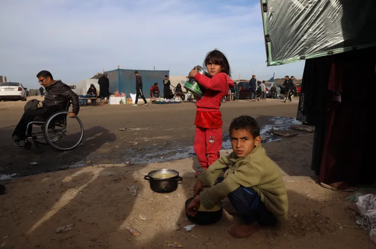 Displaced children search for food near the tents where they are staying with their families, in the city of Rafah south of the Gaza Strip.