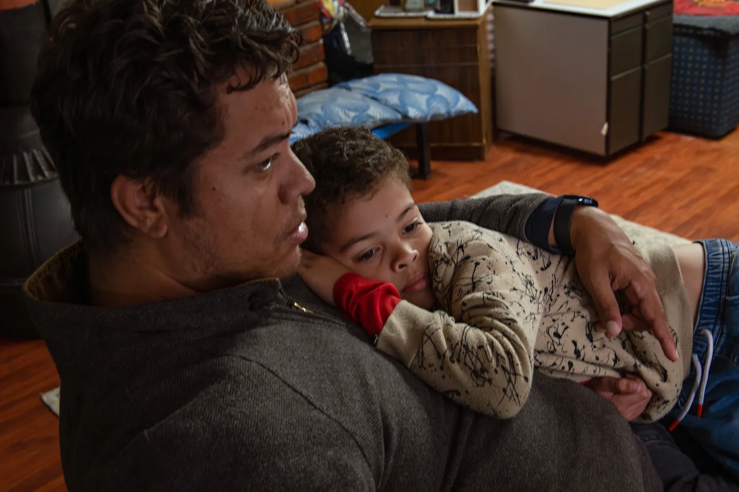 A young boy lies on his dad's chest.