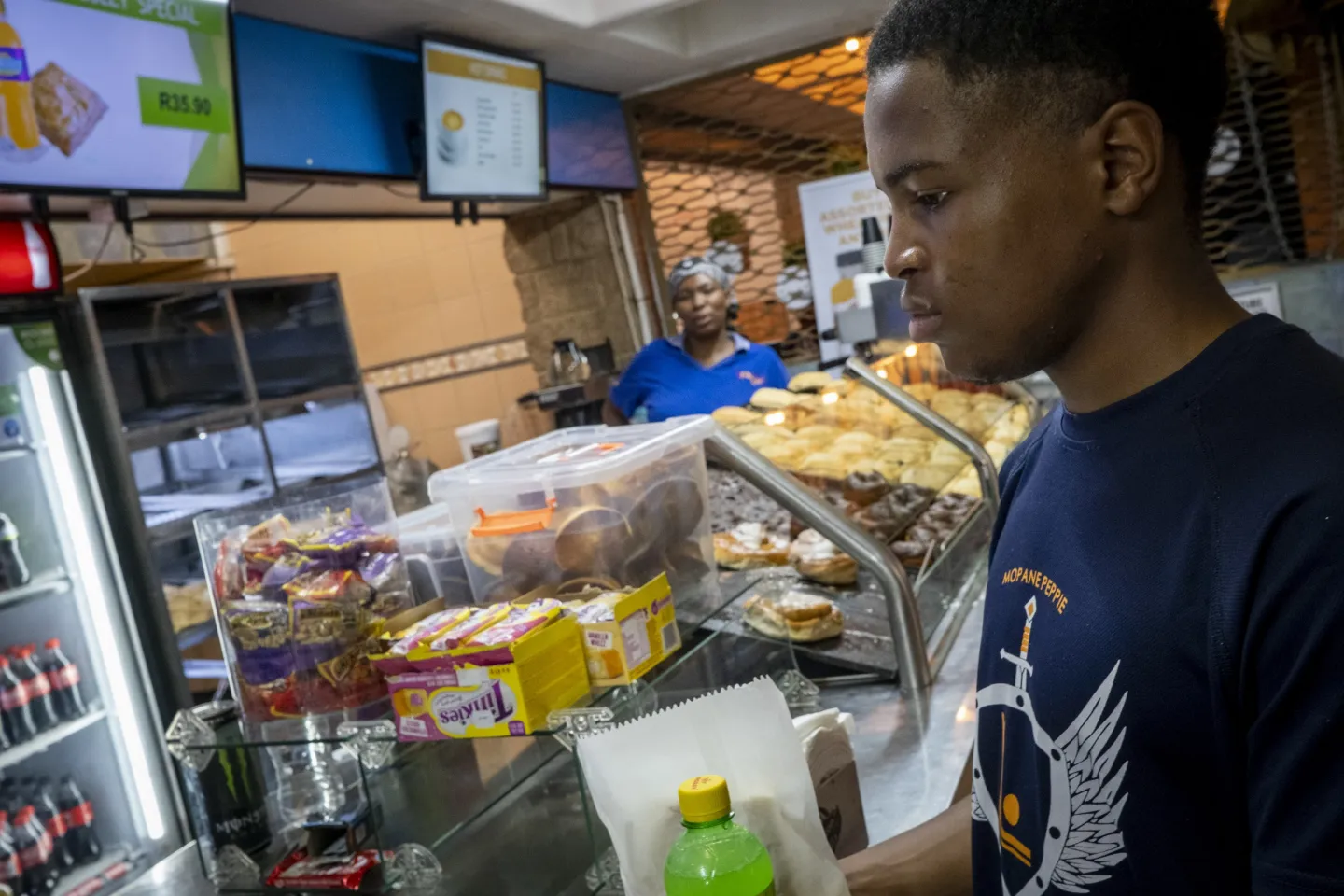 Lulutho (Lulu) Madolo, 19, a student at the University of Pretoria, buys a drink and a snack at a cafeteria on campus. 