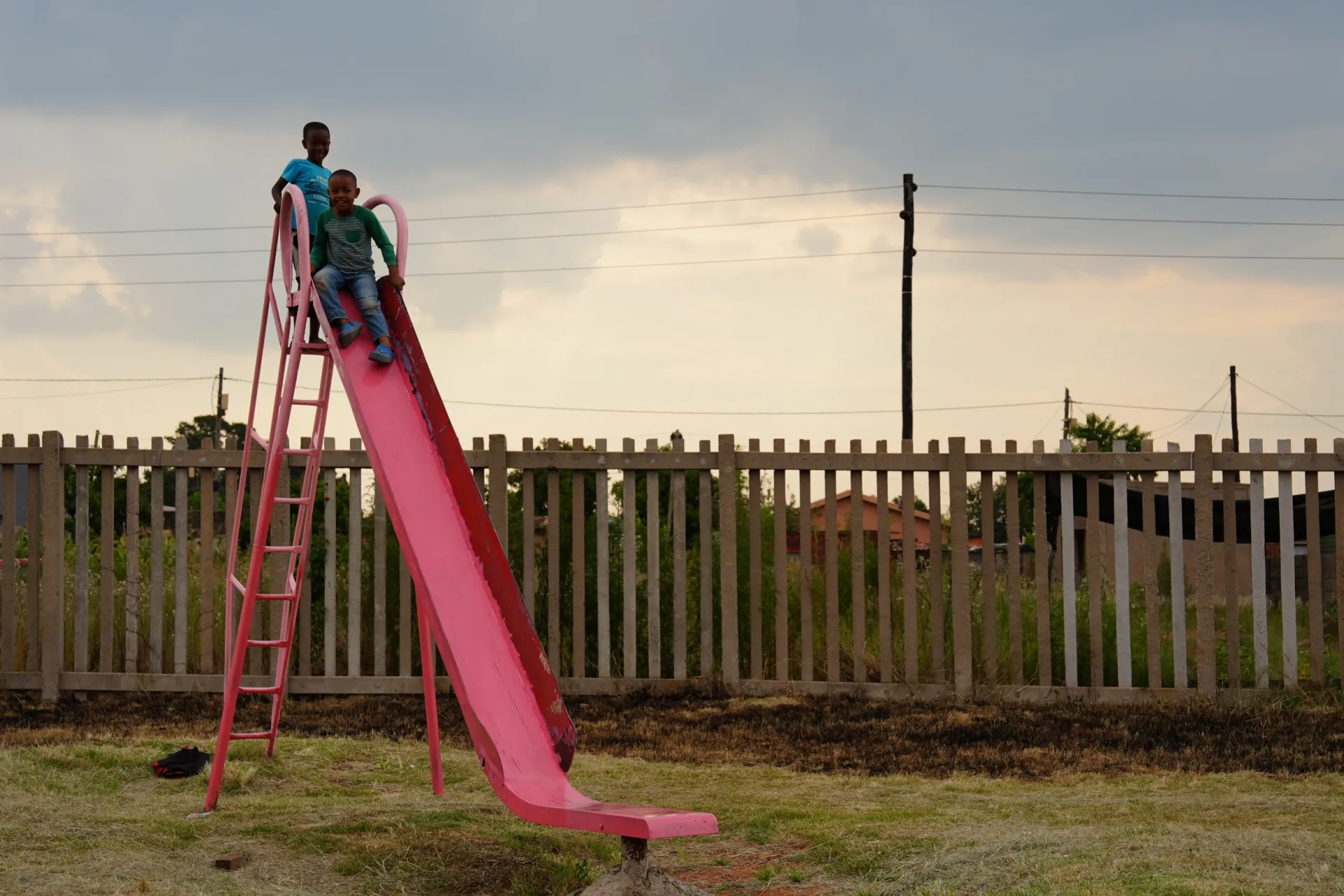 Young children playing on a slide.