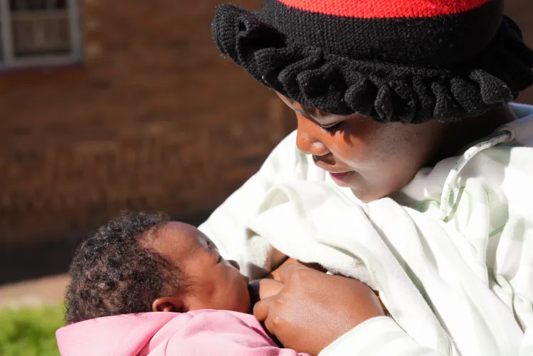A woman breastfeeds her young baby.