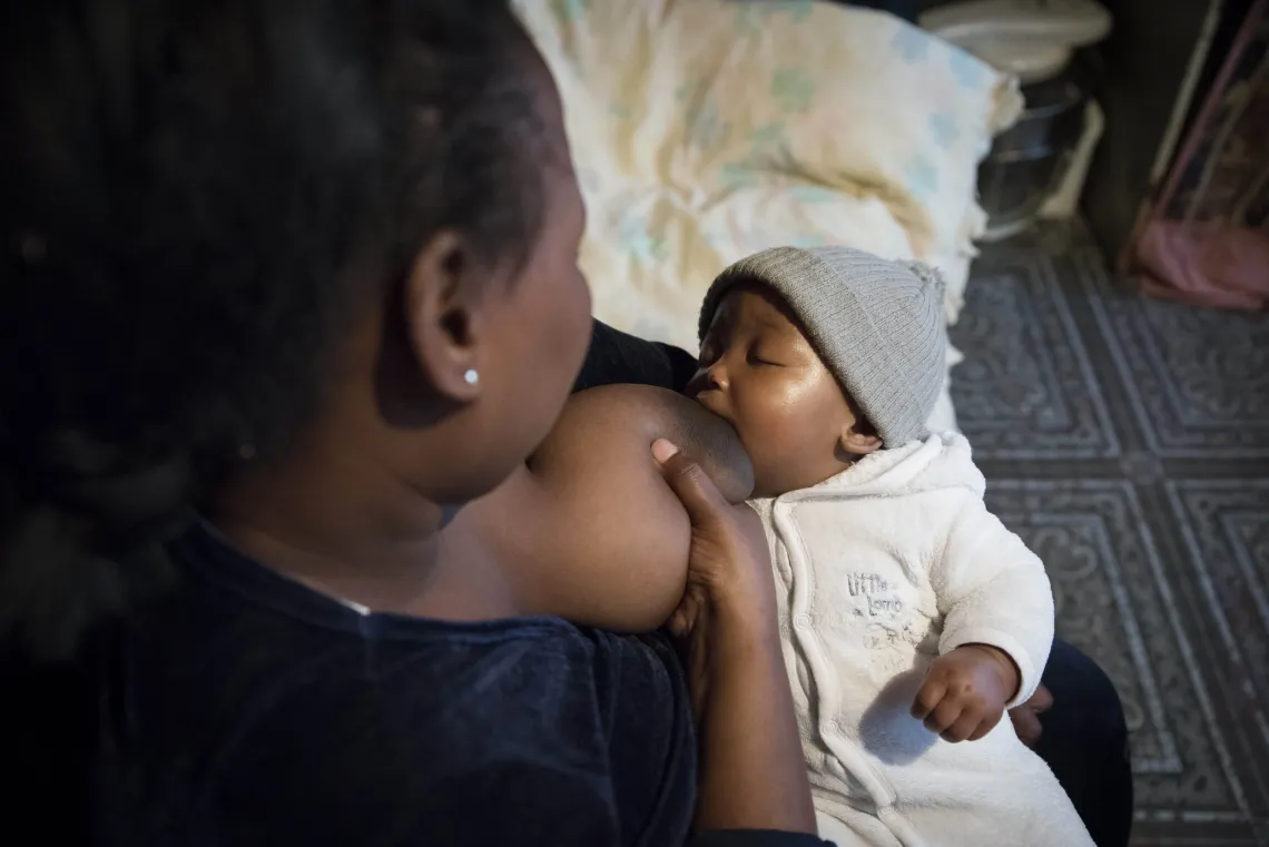 A woman breastfeeds her baby.
