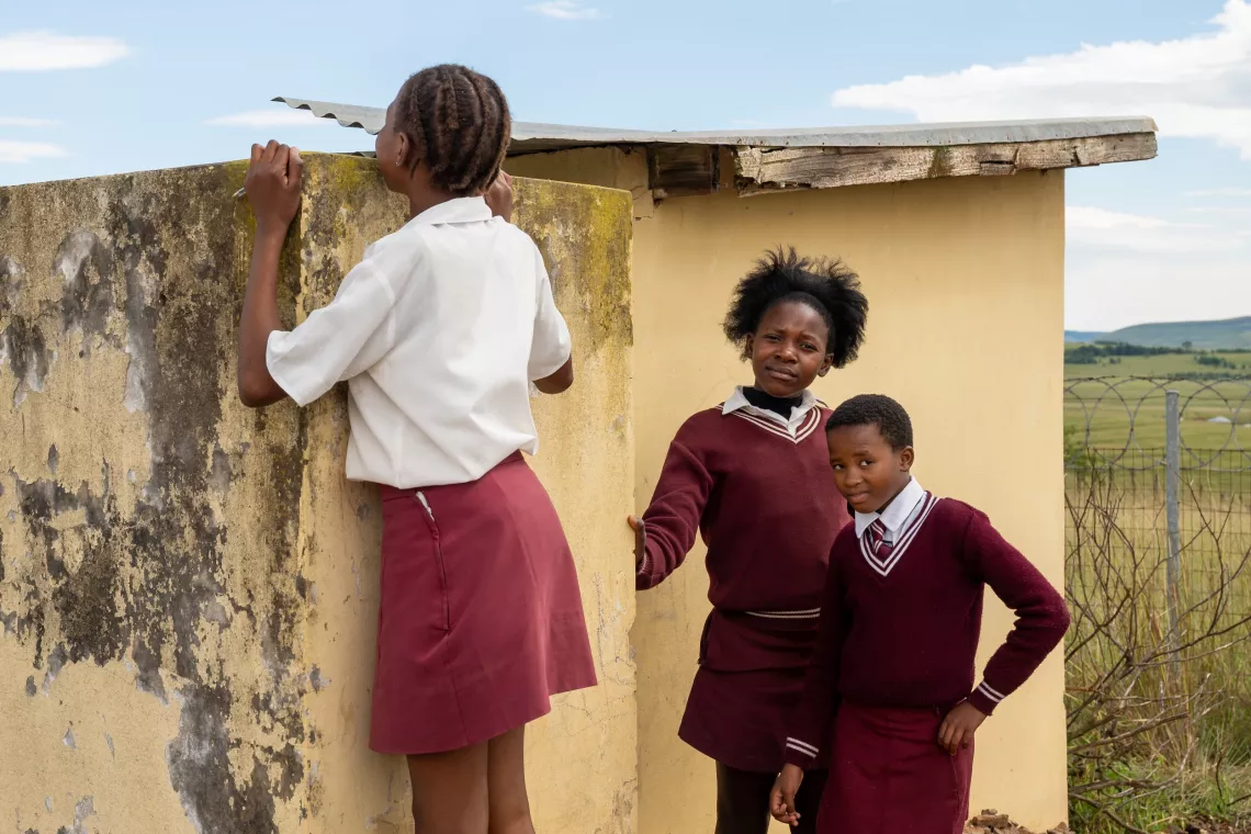 Mbambisa Primary School students stand beside their old sanitary facility in Qumbu, Eastern Cape.