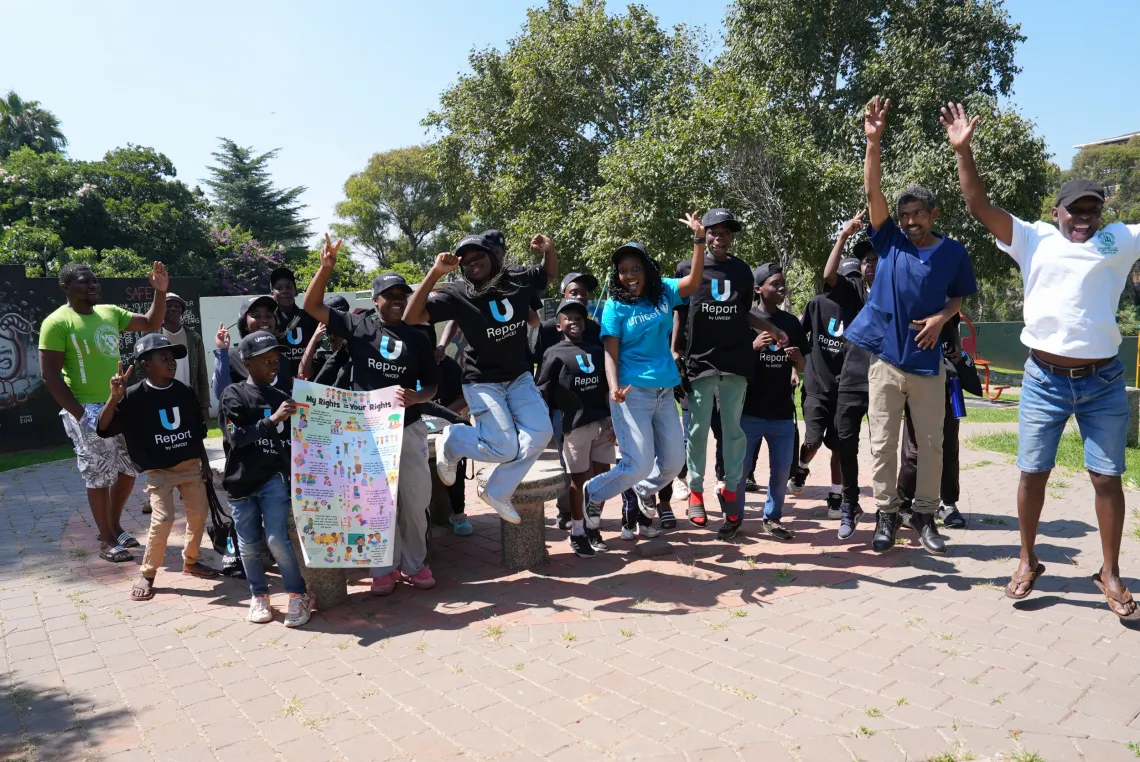 A group of youth carrying child rights posters walk down a street in Johannesburg.