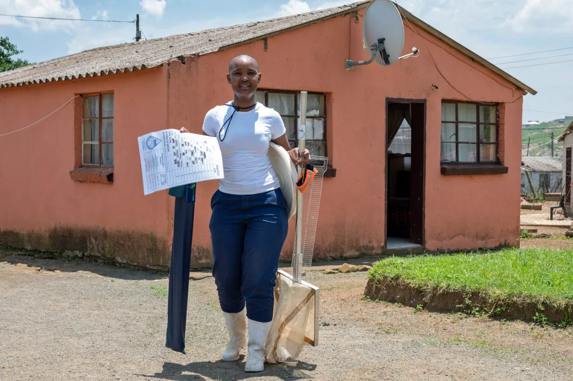 young woman holding her carrying equipment outside her home