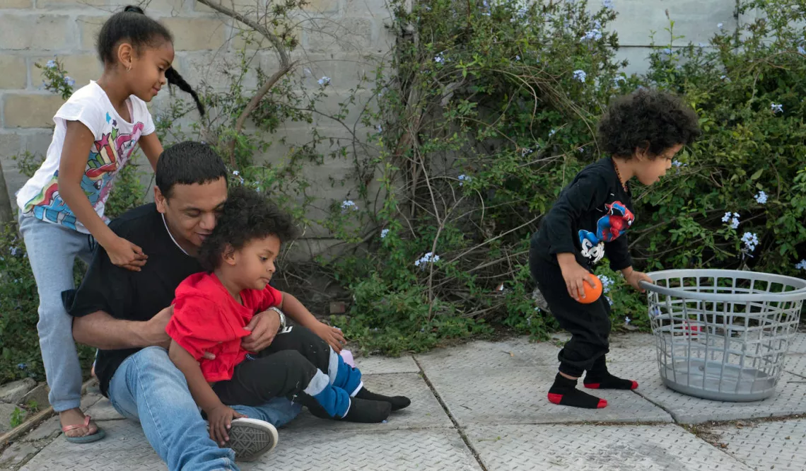 father-playing-outside-with-young-children