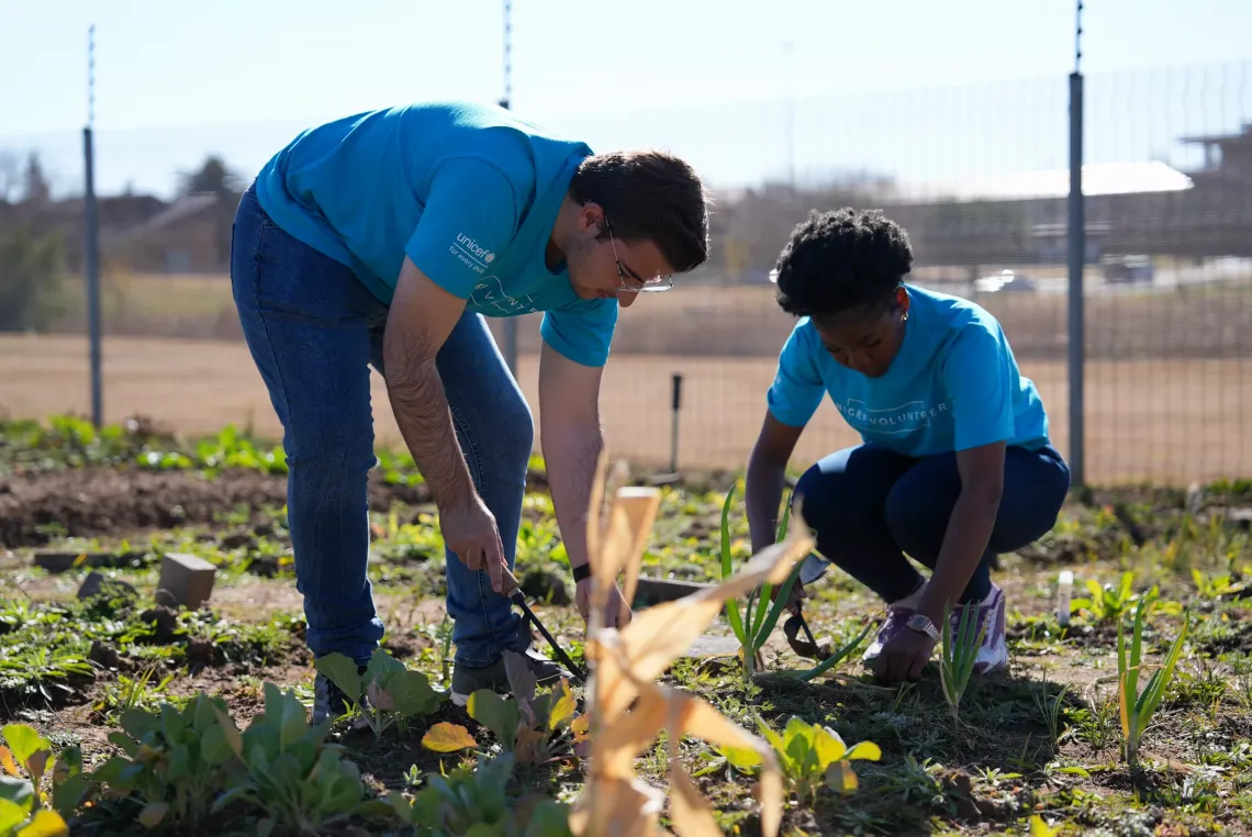 Two UNICEF Volunteers works in a vegetable garden