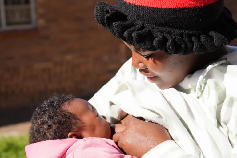 A woman breastfeeds her young baby.