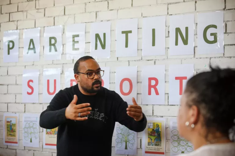 A facilitator explains something during a parenting support group meeting