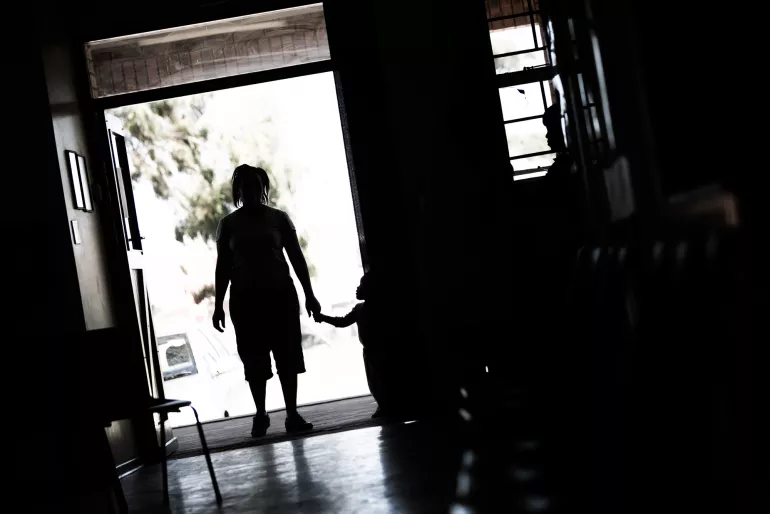 silhouette of mother and child walking out the door 