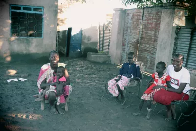 children and women sitting in a compound
