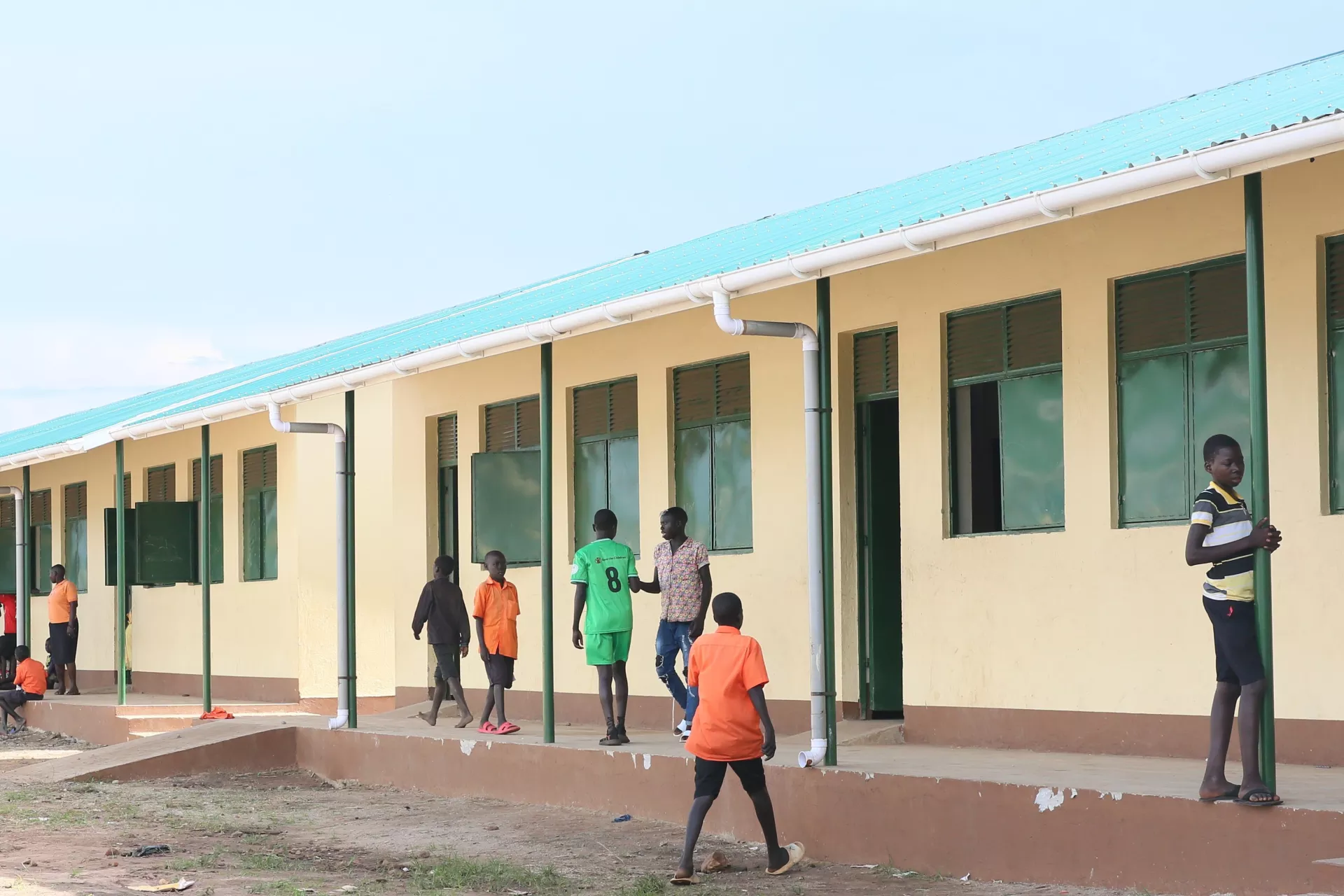 children playing on a playground in front of brand new classrooms