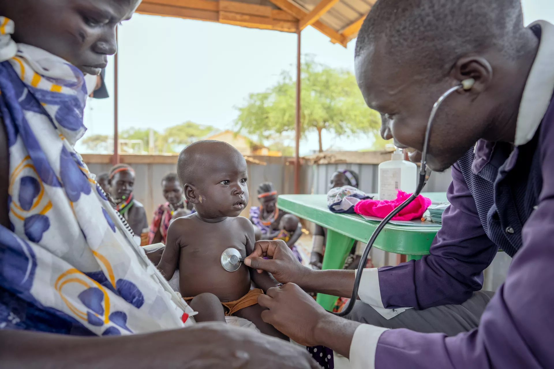 a baby is assessed by a healthcare worker, Riwoto Primary Health Center supported by UNICEF, Eastern Equatoria State, South Sudan