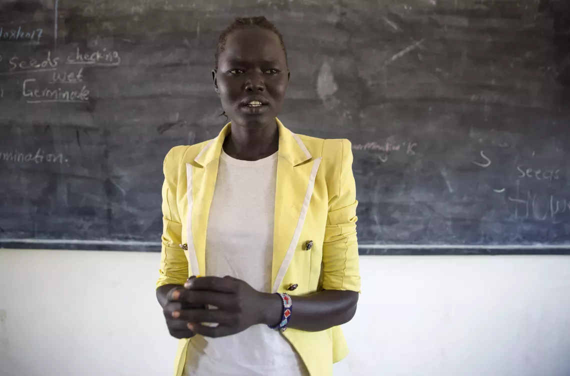 A teacher stands in a classroom in South Sudan.