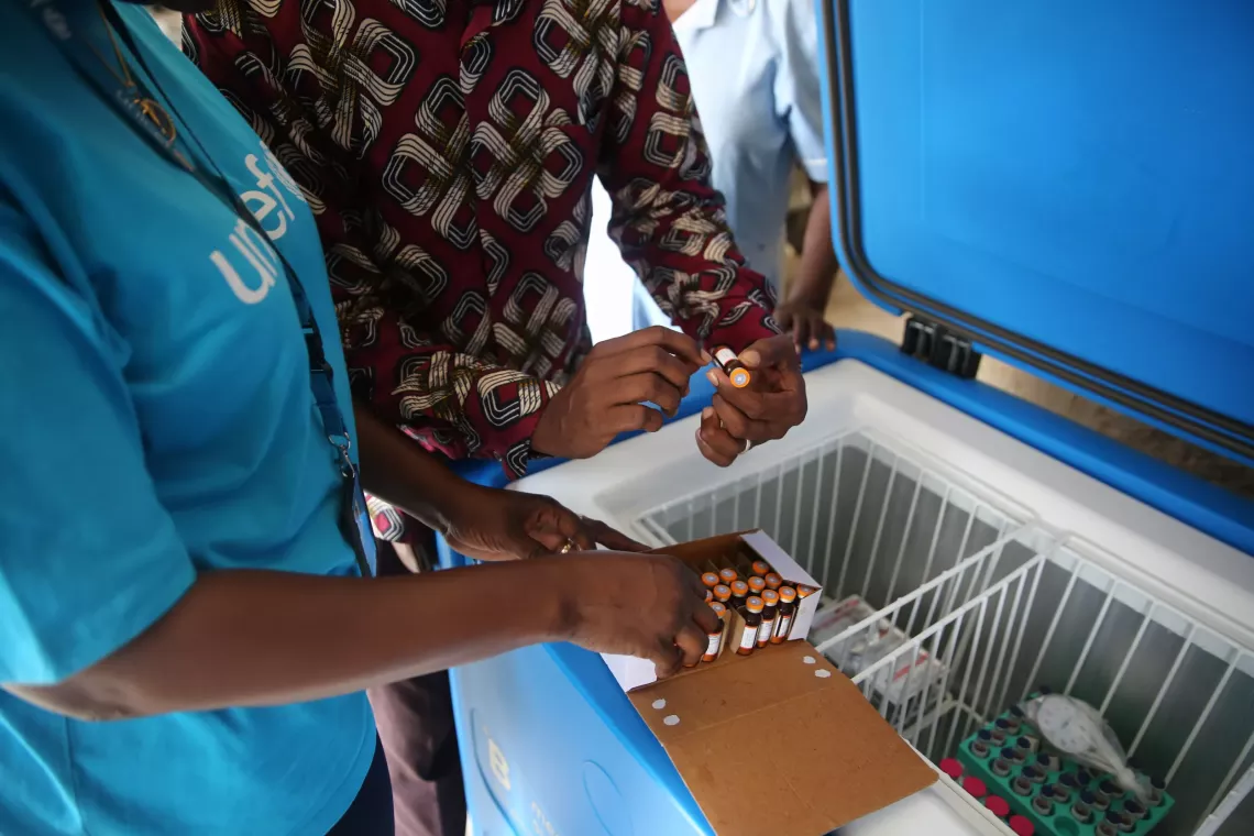 UNICEF teams taking vaccines from a refrigerator.
